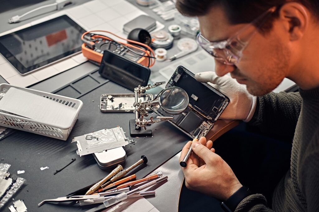 A bench technician works on a smart phone